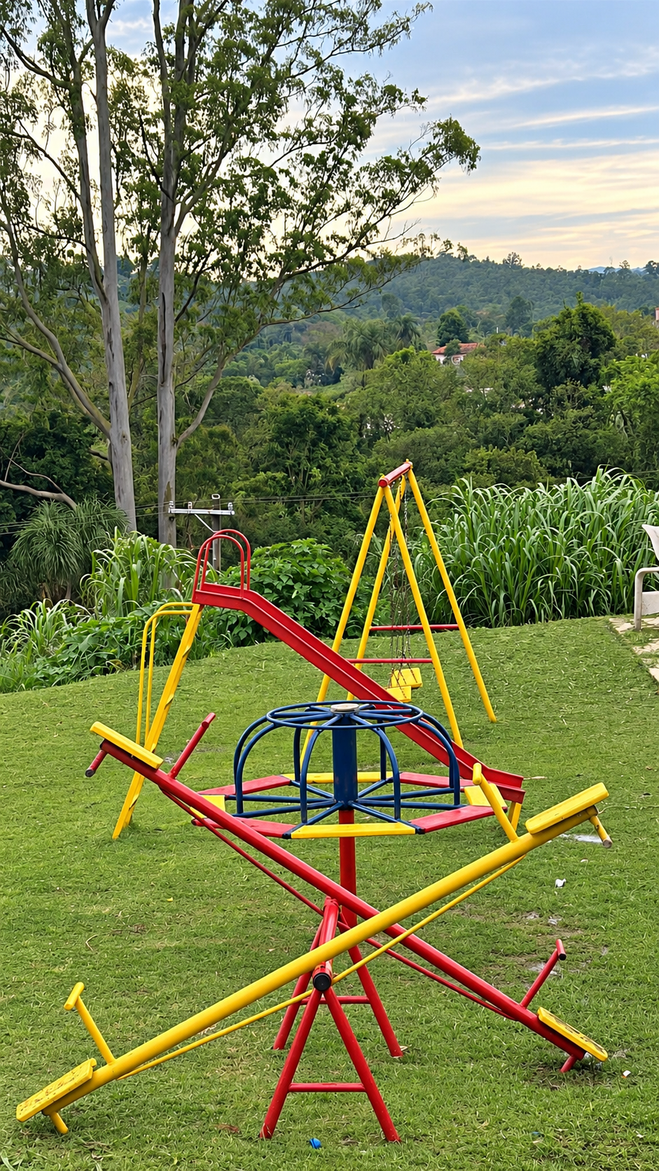 Playground infantil no gramado cercado de árvores